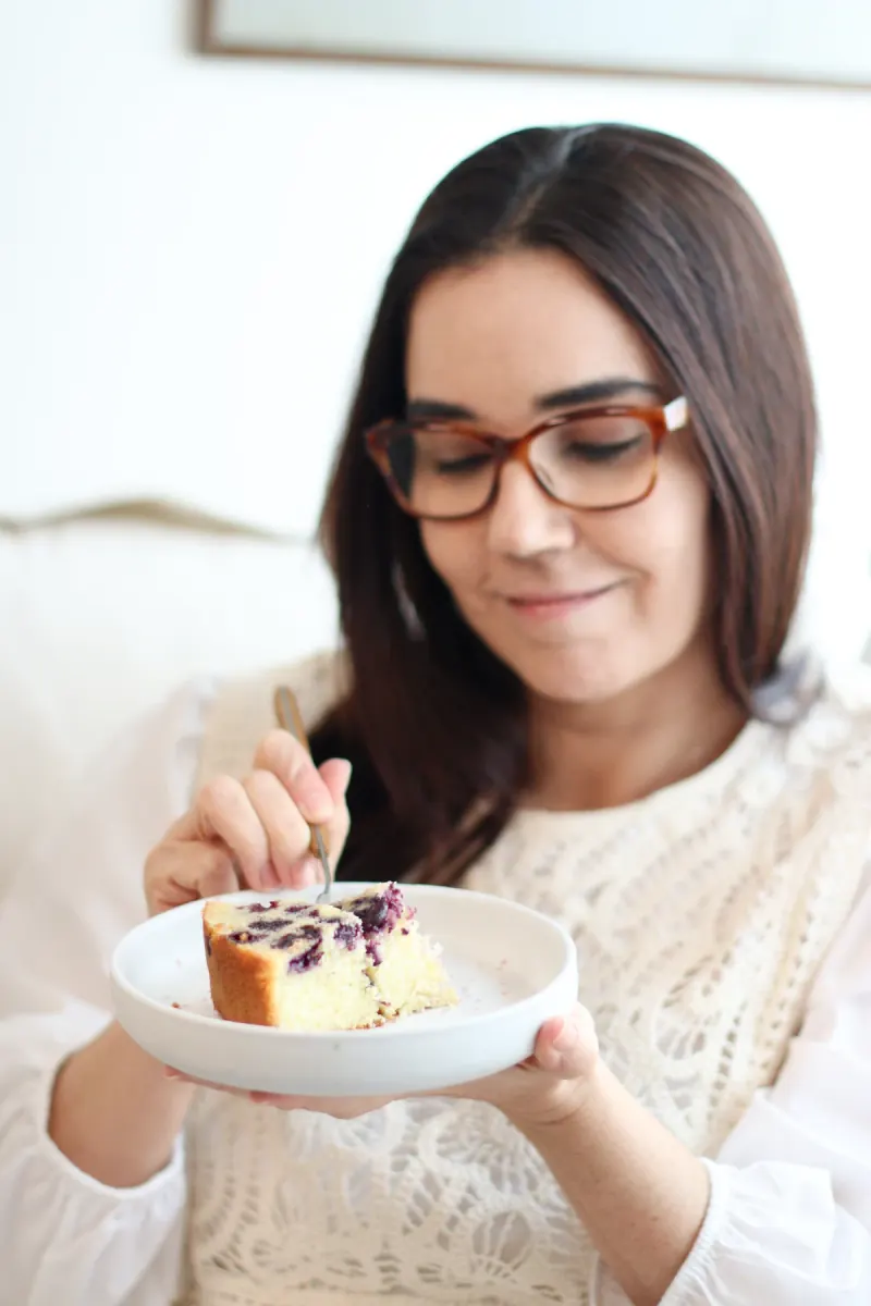 Cris Chabassus na cozinha com uma fatia de bolo